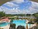 Community pool with a view of the lake and outdoor seating under the canopies and palm trees at 513 San Sebastian Ct, Davenport, FL 33837