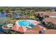 Resort-style pool featuring large pool, cabanas, hot tub, and lounge chairs overlooking the lake at 513 San Sebastian Ct, Davenport, FL 33837