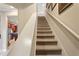 Carpeted stairway with a white banister leading to the upper level of the home at 513 San Sebastian Ct, Davenport, FL 33837