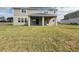 View of the backyard and covered patio with sliding glass doors providing access to the home at 977 Hawksnest Pt, Oviedo, FL 32765
