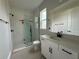 Modern bathroom featuring a glass shower, a window, and a vanity with sink and mirror at 977 Hawksnest Pt, Oviedo, FL 32765