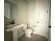 Small bathroom with pedestal sink, toilet, and white door with black hardware at 977 Hawksnest Pt, Oviedo, FL 32765