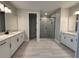 Spacious bathroom featuring dual vanities, a glass-enclosed shower, and neutral-toned tiles at 977 Hawksnest Pt, Oviedo, FL 32765