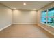 Bright bedroom with wood-look tile floors and a large window overlooking the landscape at 977 Hawksnest Pt, Oviedo, FL 32765