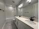 A beautifully designed bathroom with double vanity, quartz countertops, subway tile, and black finishes at 987 Hawksnest Pt, Oviedo, FL 32765