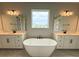 Relaxing bathroom featuring a soaking tub, separate vanities, and a window view at 987 Hawksnest Pt, Oviedo, FL 32765