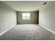 Neutral bedroom with grey carpet, base trim, and lots of natural light from the window at 987 Hawksnest Pt, Oviedo, FL 32765