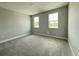 Neutral bedroom with grey carpet, base trim, and lots of natural light from the windows at 987 Hawksnest Pt, Oviedo, FL 32765