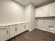 Laundry room with white cabinets, quartz countertop, wood-look flooring, sink and washer/dryer hookups at 987 Hawksnest Pt, Oviedo, FL 32765