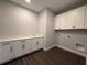 Well-lit laundry room featuring a sink, quartz countertops, and wooden floors, and a modern aesthetic at 987 Hawksnest Pt, Oviedo, FL 32765