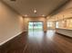 An open living room with wood floors, a patio door, and access to the kitchen, offering a modern living space at 987 Hawksnest Pt, Oviedo, FL 32765