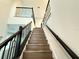 Wood staircase with dark metal railing, ascending to the upper level of the home at 987 Hawksnest Pt, Oviedo, FL 32765