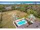 Aerial of pool, landscaping, fencing, grassy yard, and treeline in a rural setting at 24217 Adair Ave, Sorrento, FL 32776