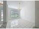 Bright dining room with white tile flooring, large window, and elegant chandelier at 24217 Adair Ave, Sorrento, FL 32776