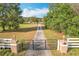 Long private driveway leading to the home, with a gated entrance and lush greenery on both sides at 24217 Adair Ave, Sorrento, FL 32776