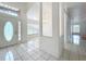 Open-concept entryway with white tile floors leading to dining area with chandelier at 24217 Adair Ave, Sorrento, FL 32776