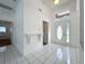 Bright entryway featuring white tile flooring, high ceilings, and decorative wall shelf at 24217 Adair Ave, Sorrento, FL 32776
