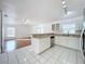 Open kitchen featuring white cabinets and tile flooring, stainless steel dishwasher and sink, with open view to living room at 24217 Adair Ave, Sorrento, FL 32776