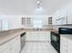 Kitchen featuring stainless steel dishwasher, black appliances, and white cabinetry at 24217 Adair Ave, Sorrento, FL 32776