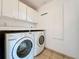 Laundry room with overhead cabinets and washer and dryer at 24217 Adair Ave, Sorrento, FL 32776