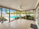 Covered patio leading to a screened-in pool and well-maintained backyard at 24217 Adair Ave, Sorrento, FL 32776