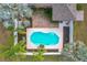 Aerial of geometric pool, showing white trim, dark mulch, green shrubs, palms, brick patio, and roof at 24217 Adair Ave, Sorrento, FL 32776