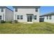 Backyard view of a two-story home with sliding glass door and grassy lawn at 2735 Virginia Pine Dr, Bartow, FL 33830