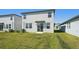 Backyard view of a two-story home with sliding glass door and grassy lawn at 2735 Virginia Pine Dr, Bartow, FL 33830
