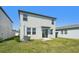 Backyard view of a two-story home with sliding glass door and grassy lawn at 2735 Virginia Pine Dr, Bartow, FL 33830