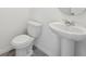 Bathroom showcasing a white toilet and a pedestal sink with modern faucet at 2735 Virginia Pine Dr, Bartow, FL 33830