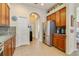 Bright kitchen with stainless refrigerator, pantry, and tiled floors at 27601 Country Stone Ct, Leesburg, FL 34748