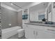 Modern bathroom with gray tile, white vanity, and granite countertop at 3314 Thicket St, Tavares, FL 32778