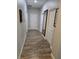 Long hallway with wood-look tile flooring, neutral paint, and framed artwork at 3811 Island Green Way, Orlando, FL 32824