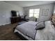 Comfortable bedroom featuring a large bed, wood-look floors, and ample natural light at 3811 Island Green Way, Orlando, FL 32824