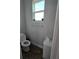 Small toilet room with toilet, storage cabinet and a window at 3811 Island Green Way, Orlando, FL 32824