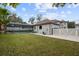Landscaped backyard with pool, garage, and white fence at 465 Songbird Way, Apopka, FL 32712