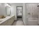 Bright bathroom with double vanity and marble shower/tub combo at 465 Songbird Way, Apopka, FL 32712