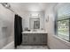 Modern bathroom with gray vanity, white tile, and soaking tub at 465 Songbird Way, Apopka, FL 32712