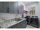 Functional laundry room with granite countertops and modern appliances at 465 Songbird Way, Apopka, FL 32712