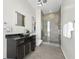 Modern bathroom with a large glass shower, dark vanity, and city view at 155 S Court Ave # 2908, Orlando, FL 32801