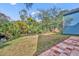 Spacious backyard with a creek, lush greenery, and a brick patio, offering a private outdoor space at 1445 Creekside Cir, Winter Springs, FL 32708