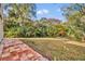 Large backyard featuring a red brick patio and lush landscaping, perfect for enjoying the outdoors at 1445 Creekside Cir, Winter Springs, FL 32708