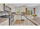 Well-lit kitchen boasts stainless appliances, granite countertops, a mosaic backsplash, and light-colored cabinetry at 1445 Creekside Cir, Winter Springs, FL 32708
