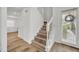 A staircase showcasing wood-look steps with white risers and railing, complemented by natural light from a nearby door at 1445 Creekside Cir, Winter Springs, FL 32708