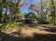 Home's back exterior, featuring a screened porch and trees at 2663 Magnolia Rd, Deland, FL 32720