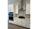 Modern kitchen features white cabinets, gas cooktop, and stainless steel range hood at 2817 Willowseed Ln, Saint Cloud, FL 34772