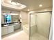 Bright bathroom features a dual sink vanity, a soaking tub, and a glass-enclosed shower at 7652 Whisper Way # 104, Reunion, FL 34747