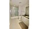 Clean bathroom with a glass-enclosed shower and bathtub, white cabinets, and granite countertops, offering modern comfort at 7652 Whisper Way # 104, Reunion, FL 34747