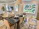 Elegant dining area with a sleek black table, seating for eight, and bright natural light at 7652 Whisper Way # 104, Reunion, FL 34747