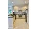 Well-lit kitchen with stainless steel appliances, granite countertops, and white cabinetry at 7652 Whisper Way # 104, Reunion, FL 34747